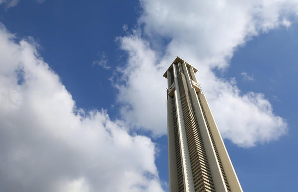 Looking up at the UCR Bell Tower against a blue sky with white clouds