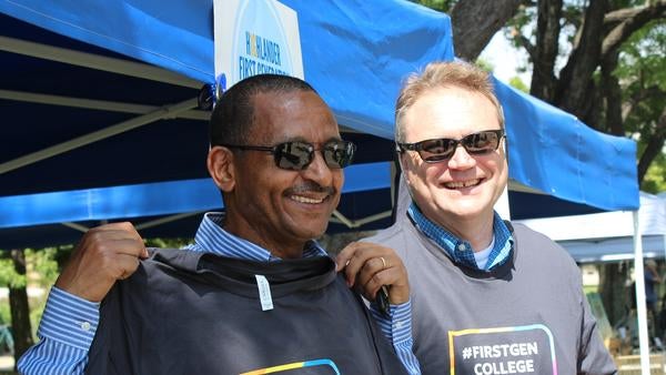 Two first-generation faculty members holding t-shirts