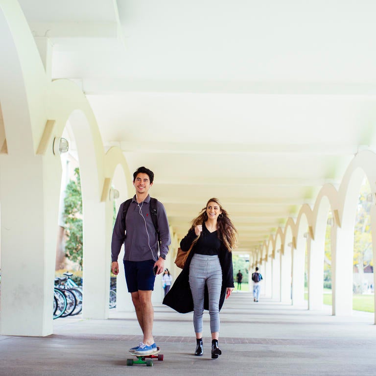 Two students travelling through the Rivera Library Arches