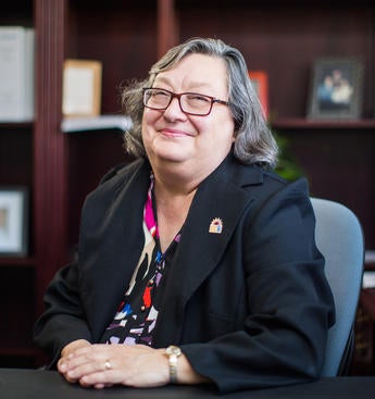 Provost Cynthia Larive, 2000 scale Provost Larive at a desk smiling